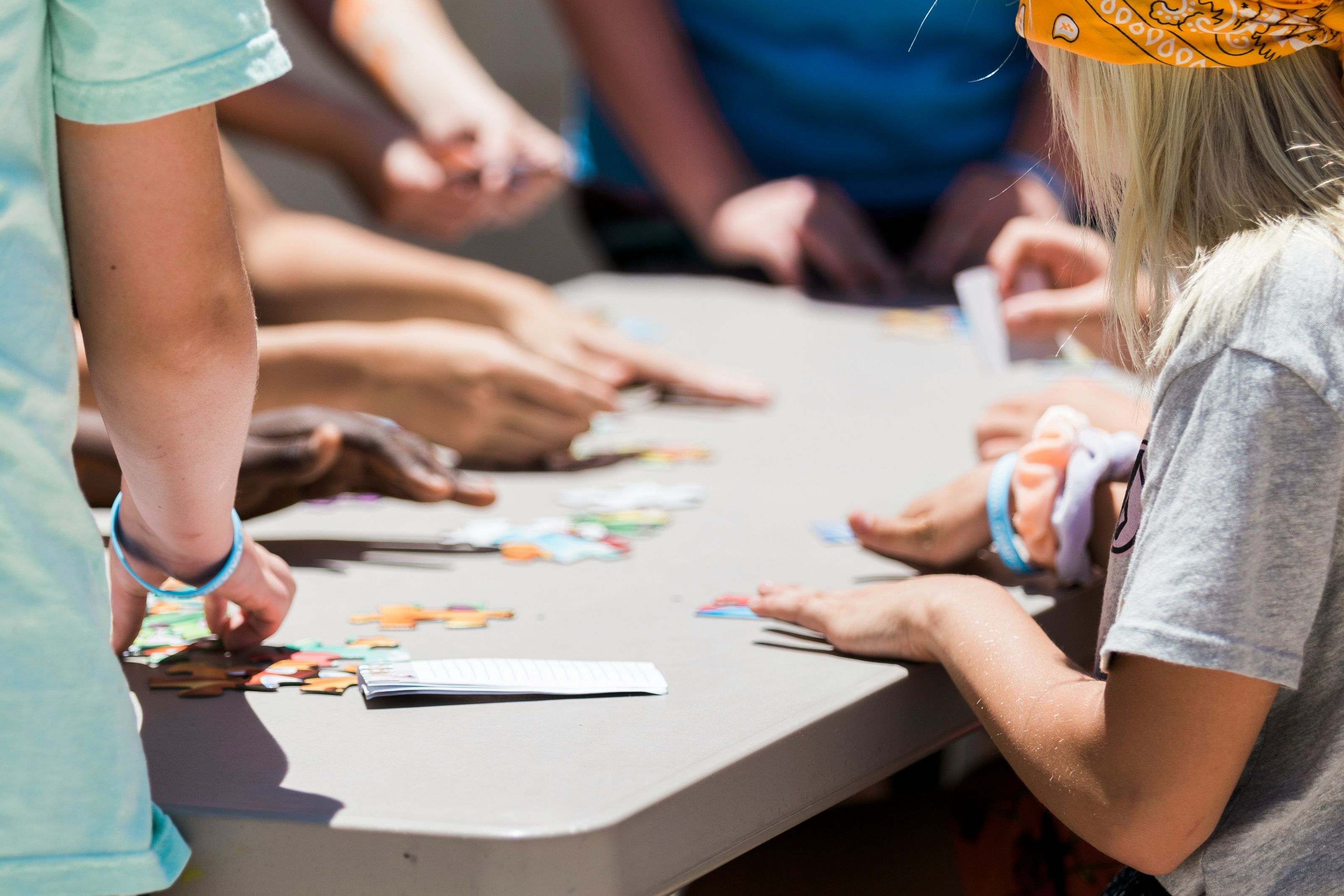 Children's hands playing board game at table, pieces and game board visible